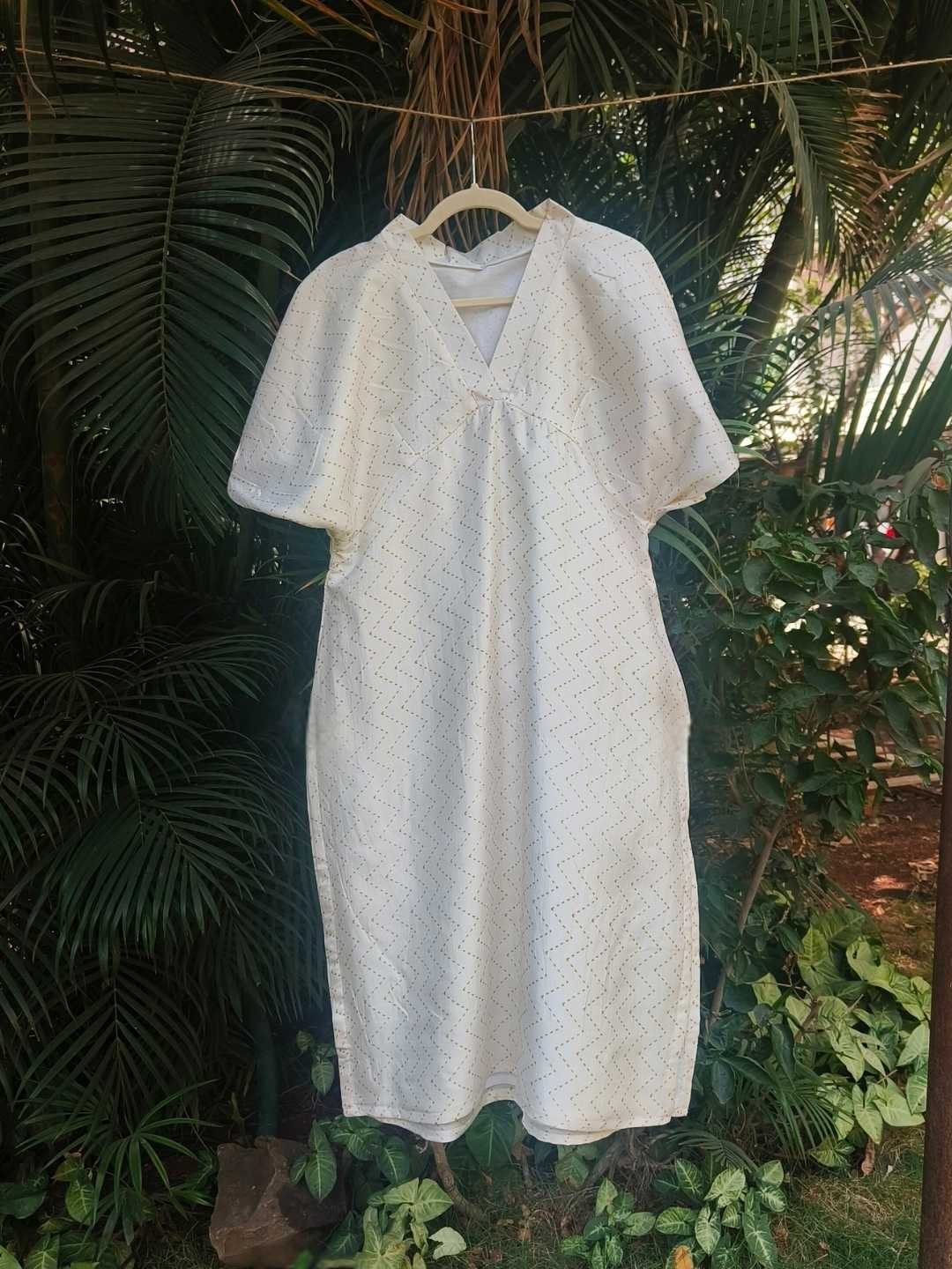 Selene Kurta- Kosa Silk White Kurta | Jhultaru. Fabric: 100% Handwoven Kosa Silk Color: Ivory White with soft golden zigzag weave Design: Mid-length kurta with V-neck, soft gathers at bust, elbow sleeves- Selene Kurta in handwoven kosa silk with subtle gold zigzag weave. Easy-fit silhouette with gathered V-neck. Sustainable, eco-friendly, timeless elegance.