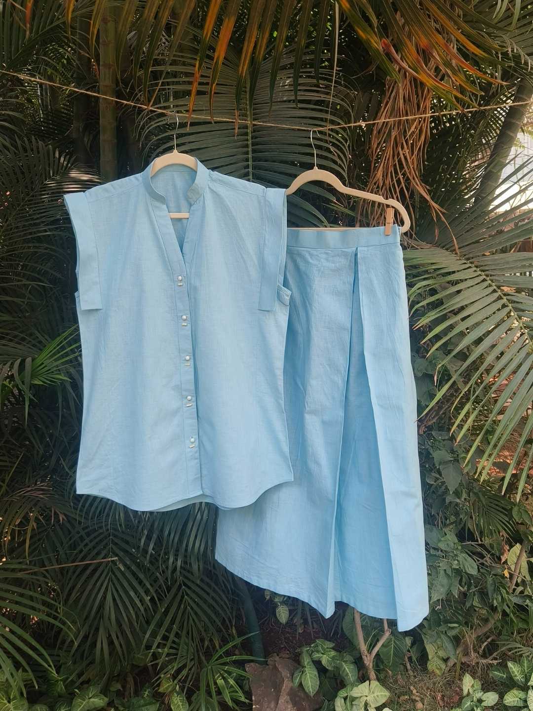 Noa Co-ord Set- Linen Shirt & Skirt in Sky Blue | Jhultaru. 100% Linen- naturally breathable, biodegradable, sustainable, eco-friendly and perfect for warm days.  Shirt buttons: Real shell buttons, hand-stitched.- The Noa Co-ord Set by Jhultaru pairs a structured linen shirt with shell buttons and a wrap skirt in sky blue - graceful, breathable, and timeless.