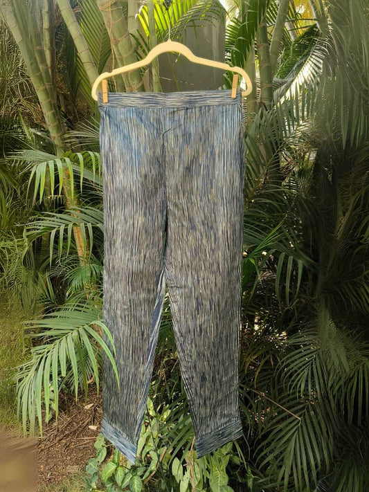 Siona Pants- Handwoven Tussar Silk | Jhultaru by Jhultaru. Fabric: 100% Handwoven Tussar Silk  Color: Indigo with natural striationsStraight, tailored fit. Ankle lengthElasticated back waistband for comfortClean hem finish for a refined look- Handwoven tussar silk Siona Pants in striated indigo tones. Straight fit, ankle length, and artisanally crafted comfort. A wardrobe staple that is eco-friendly and sustainable